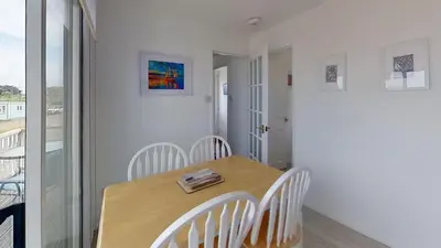 a dining room with a wooden table and chairs at E20 The Firs, Riviere Towans in Hayle