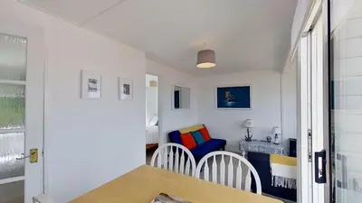 a room with a table and a chair and a table at E20 The Firs, Riviere Towans in Hayle