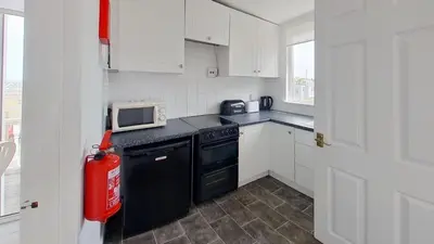 a kitchen with a black stove and a microwave at E20 The Firs, Riviere Towans in Hayle