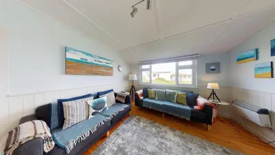 a living room with two couches and a window at E23 Porthpean, Riviere Towans in Hayle