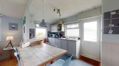 a kitchen with a table and a counter top at E23 Porthpean, Riviere Towans in Hayle