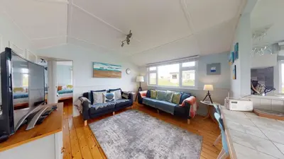 a living room with two couches and a tv at E23 Porthpean, Riviere Towans in Hayle