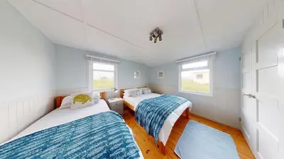 two beds in a room with two windows at E23 Porthpean, Riviere Towans in Hayle