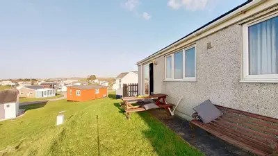 a bench sitting on the side of a house at E24 Smeranda, Riviere Towans in Hayle