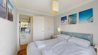 a bedroom with a white bed and pictures on the wall at E28 HI-Up, Riviere Towans in Hayle