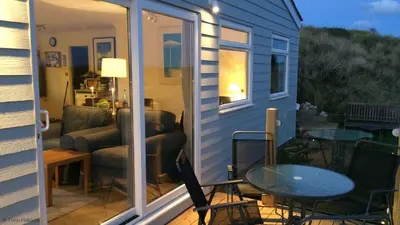 a screened in porch of a tiny house with a table and chairs at E28 HI-Up, Riviere Towans in Hayle