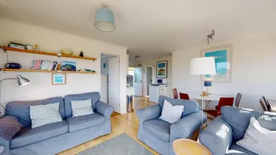 a living room with two blue couches and a table at E28 HI-Up, Riviere Towans in Hayle