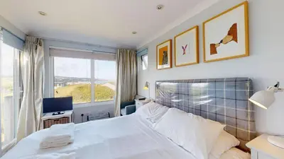 a bedroom with a white bed and a window at E28 HI-Up, Riviere Towans in Hayle
