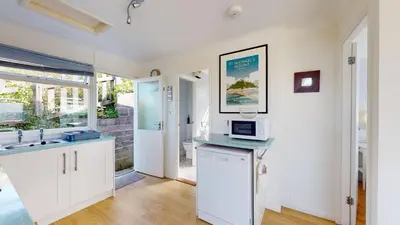 a kitchen with a sink and a microwave on a counter at E28 HI-Up, Riviere Towans in Hayle