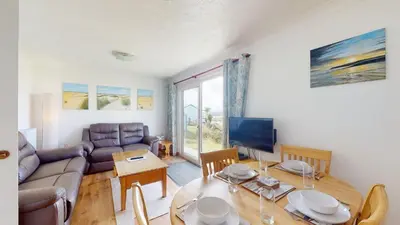 a living room with a couch and a table at E30 Lant View, Riviere Towans in Hayle