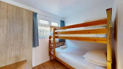 two bunk beds in a small room with a window at E30 Lant View, Riviere Towans in Hayle