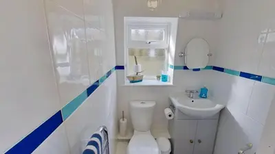 a small bathroom with a toilet and a sink at E39 Craigmore, Riviere Towans in Hayle