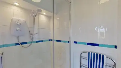 a shower with a glass door in a bathroom at E39 Craigmore, Riviere Towans in Hayle