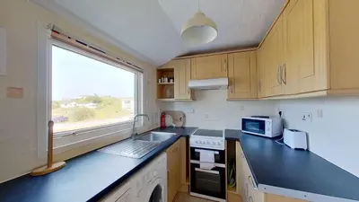 a small kitchen with a sink and a window at E37 Blue Haze, Riviere Towans in Hayle