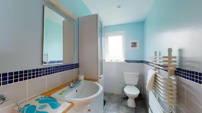 a bathroom with a sink and a toilet and a mirror at E46 Dunroven, Riviere Towans in Hayle