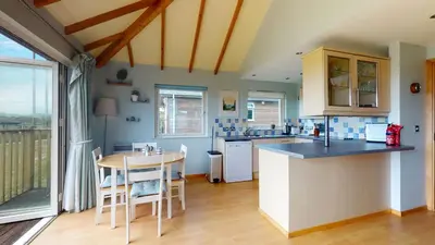 a kitchen with a counter and a table with chairs at E46 Dunroven, Riviere Towans in Hayle