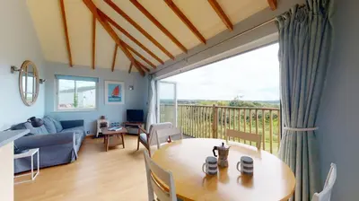 a living room with a table and a couch at E46 Dunroven, Riviere Towans in Hayle