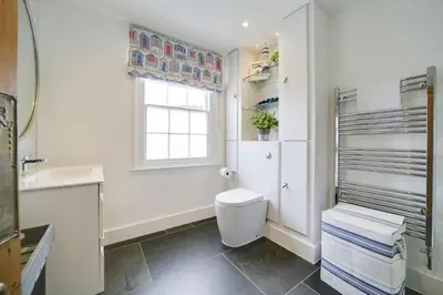 a bathroom with a toilet and a sink and a window at Church Hill House in Port Isaac