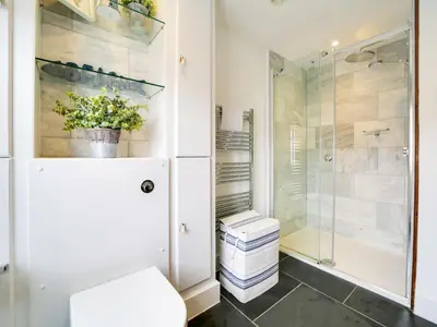 a bathroom with a toilet and a glass shower at Church Hill House in Port Isaac