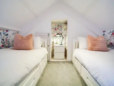 two beds in a room with white walls at Church Hill House in Port Isaac