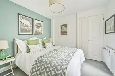 a bedroom with a large bed with green accents at Old Cobblers in Port Isaac