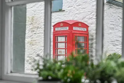 a red phone booth on the side of a building at Old Cobblers in Port Isaac
