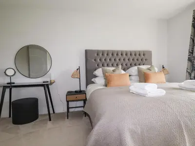 a bedroom with a large bed with a large mirror at Lavender House in Newquay
