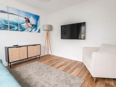 a living room with a couch and a flat screen tv at Lavender House in Newquay