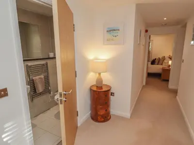 a hallway with a lamp on a wooden table at Moonsail in Carbis Bay