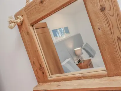 a mirror in a wooden frame on a wall at Moonsail in Carbis Bay