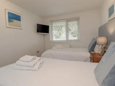 a bedroom with two beds and a window at Moonsail in Carbis Bay