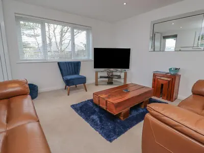 a living room with a couch and a flat screen tv at Moonsail in Carbis Bay