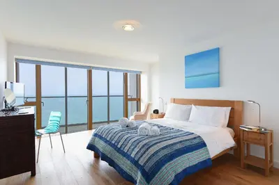 a bedroom with a bed with towels on it at Glas Mor in Carbis Bay