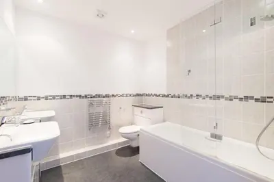 a white bathroom with a toilet and a sink at Glas Mor in Carbis Bay