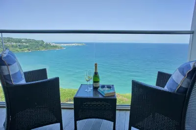 a table with a bottle of wine and two glasses at Glas Mor in Carbis Bay