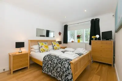 a bedroom with a bed and a tv and a window at The Waves in St Ives
