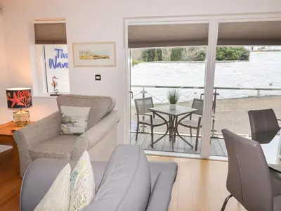 a living room with a couch and chairs and a table at The Waves in St Ives