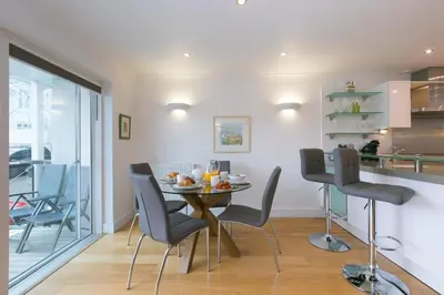 a dining room and kitchen with a table and chairs at The Waves in St Ives