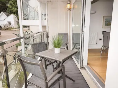 a balcony with a table and chairs on a balcony at The Waves in St Ives