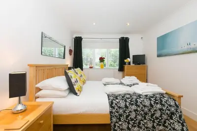 a bedroom with a bed and a desk and a window at The Waves in St Ives
