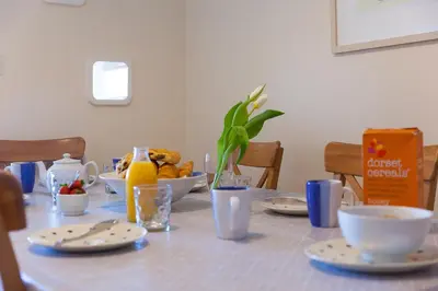 a table with plates and bowls of food on it at Dolphin Watch in Carbis Bay