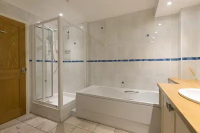 a bathroom with a shower and a tub and a sink at Dolphin Watch in Carbis Bay