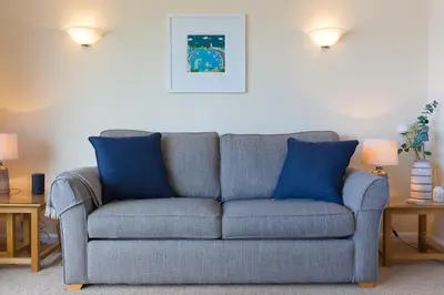 a blue couch in a living room with two blue pillows at Dolphin Watch in Carbis Bay