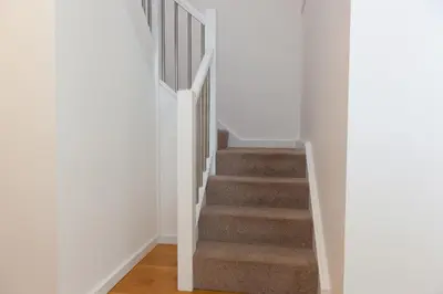 a staircase in a home with white walls at Chy Lowen in Carbis Bay