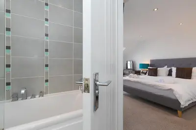 a bedroom with a bed next to a bath tub at Chy Lowen in Carbis Bay