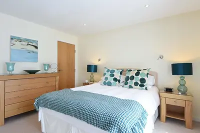 a bedroom with a bed with a blue and white blanket at Ocean View in Carbis Bay