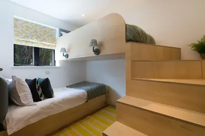 a bedroom with a bed and stairs in a room at Gwel An Chapel in Carbis Bay