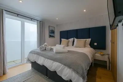 a bedroom with a large bed with a large window at Gwel An Chapel in Carbis Bay