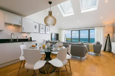 a kitchen and living room with a table and chairs at Gwel An Chapel in Carbis Bay