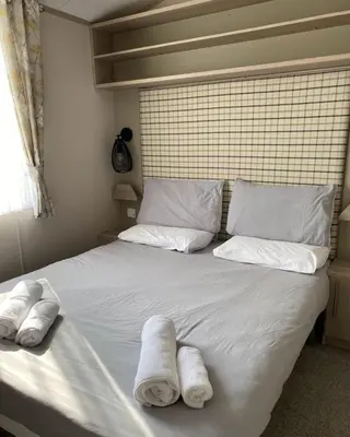 a bedroom with a bed with towels on it at Luxury Holiday Home Sleeps 6 Pet Friendly in St Austell